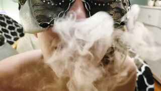Smoking mistress Mylie Blonde in a mask takes a puff of a cigarette with her cunt